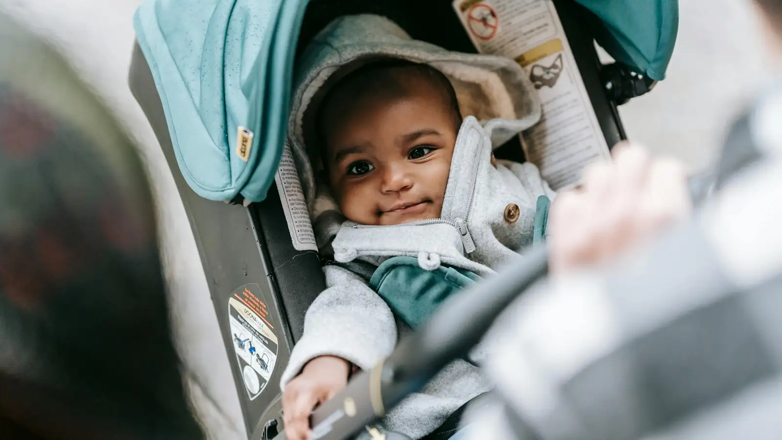 Parent carrying an infant car seat